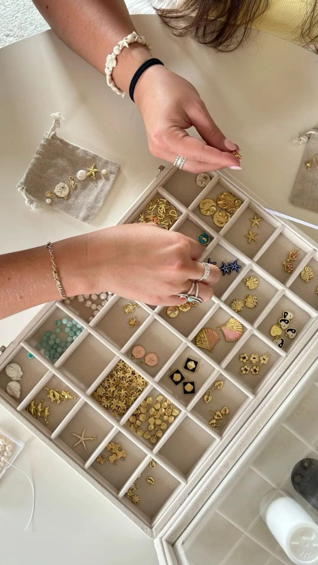 Charms werden aus einem großen, sortierten Charm-Tablett ausgewählt
