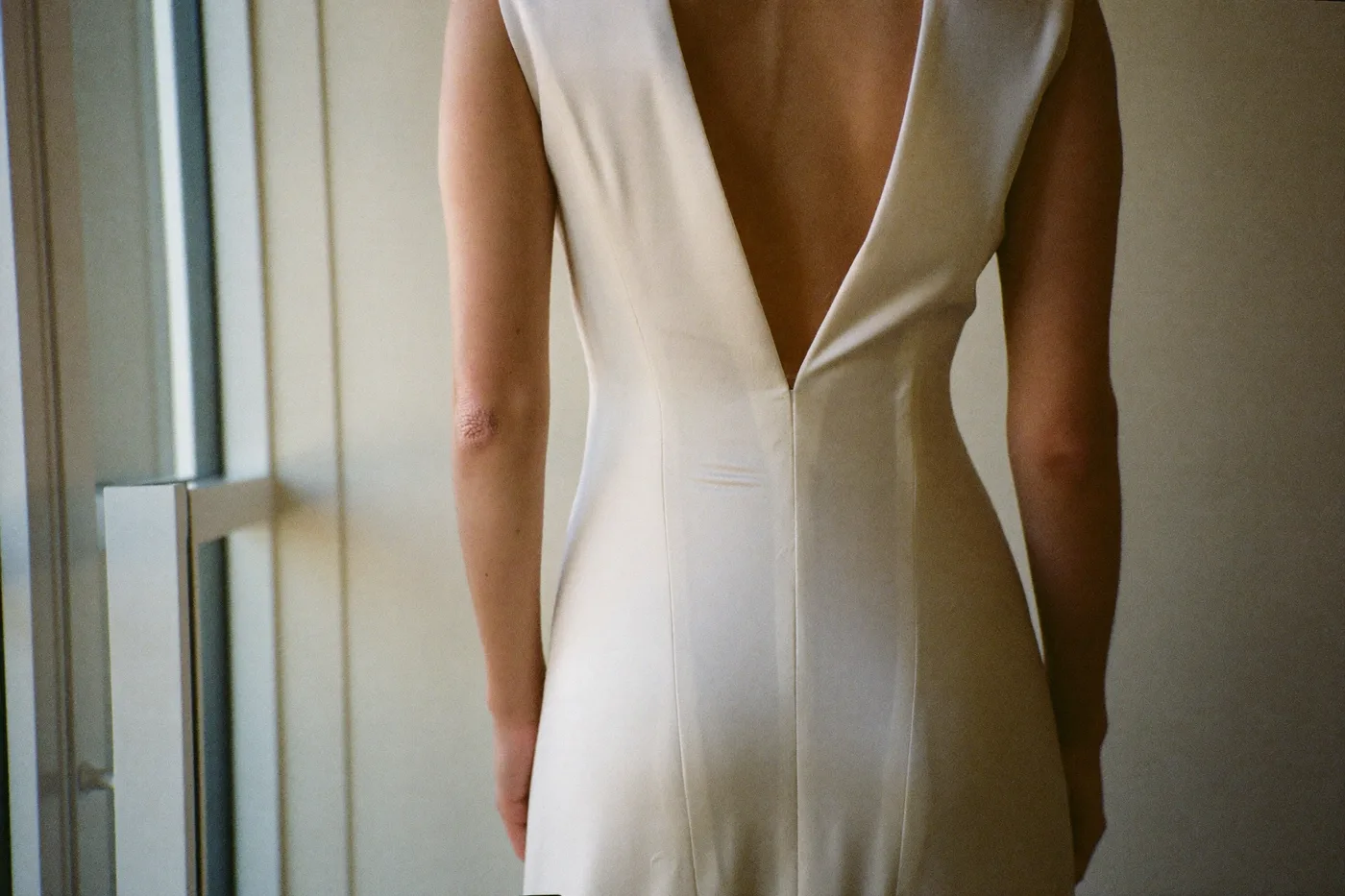Braut in einem schlichten, fließenden Brautkleid im Tageslicht