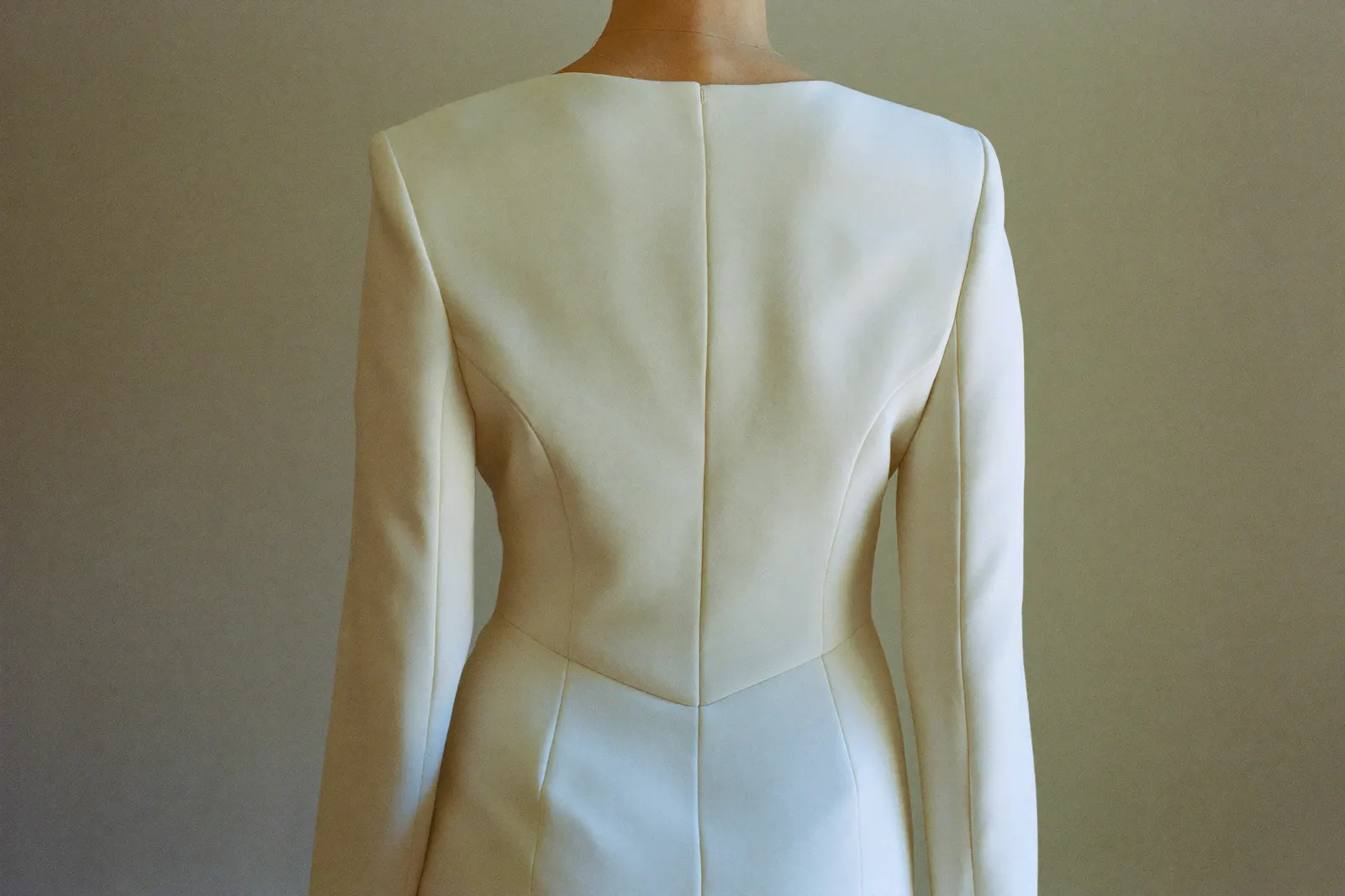 Braut im schlichten Standesamtkleid in ruhigem Tageslicht, Stoff und Schnitt im Mittelpunkt, faceless
